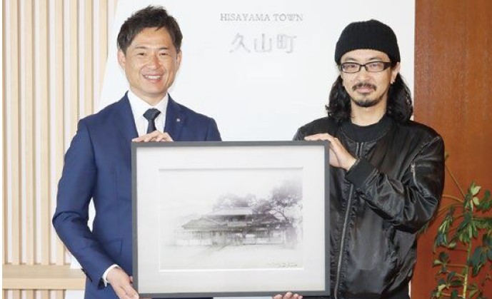 寄贈された絵画を持つ西村町長と鎌田さん