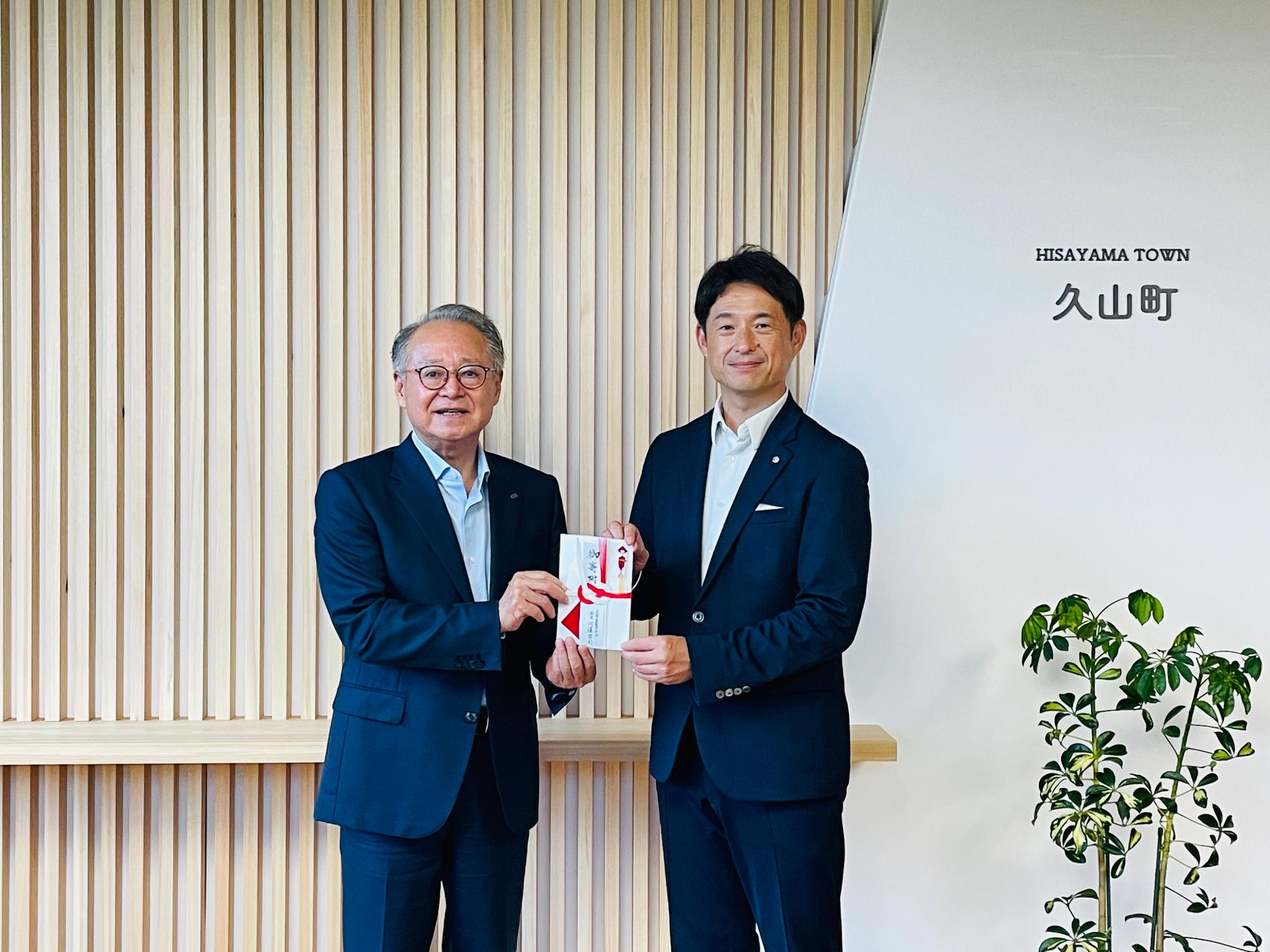 目録と共にうつる株式会社久原本家グループ本社代表取締役社長河邉哲司氏と久山町長西村勝