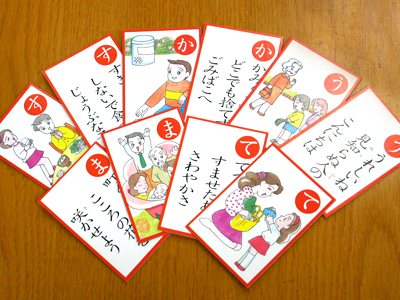 扇状に並べられたかるたの絵札と読み札の写真