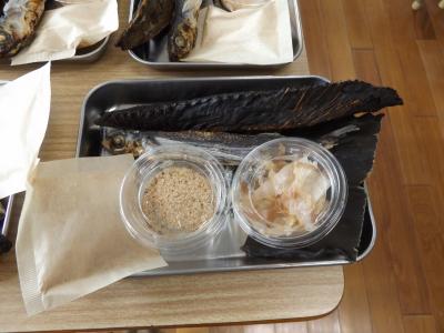 昆布や鰹、透明の容器に入っただしと削り節が銀色のトレーに置かれている写真