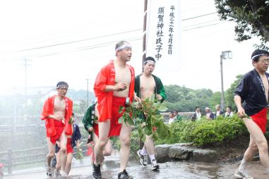 赤褌法被姿の男性たちが駆け足で家々を周っている様子の写真