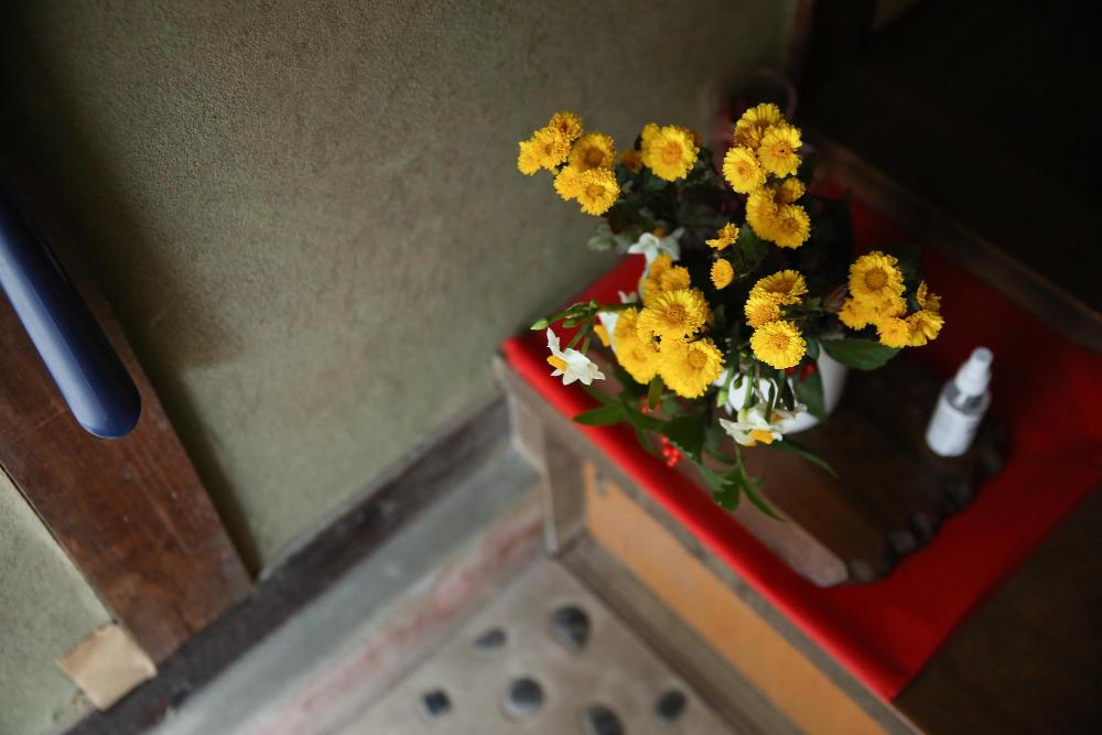 玄関に飾られた花と消毒スプレー