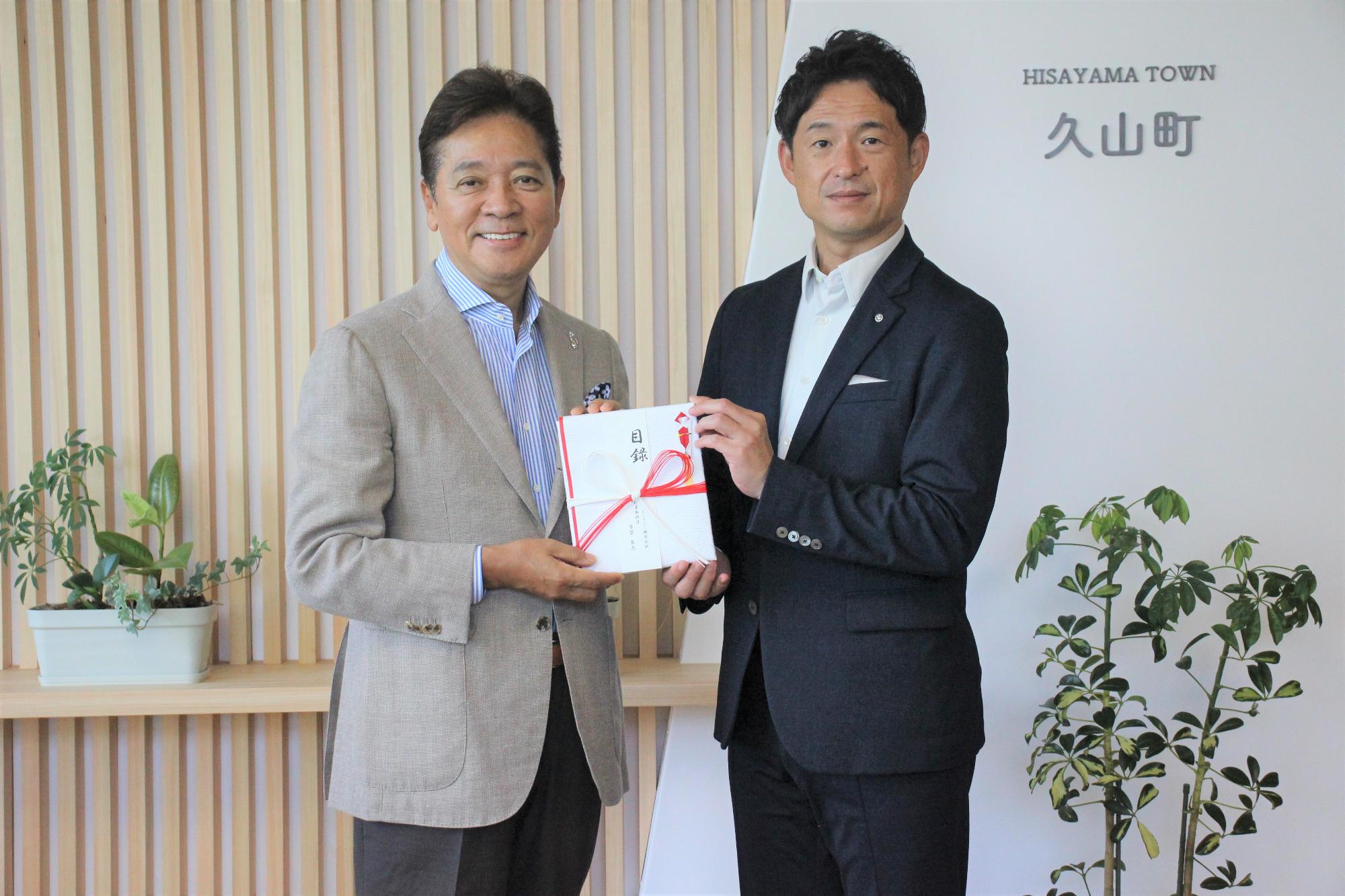 目録と共にうつる株式会社久山カントリー代表取締役社長古賀良太氏と久山町長西村勝