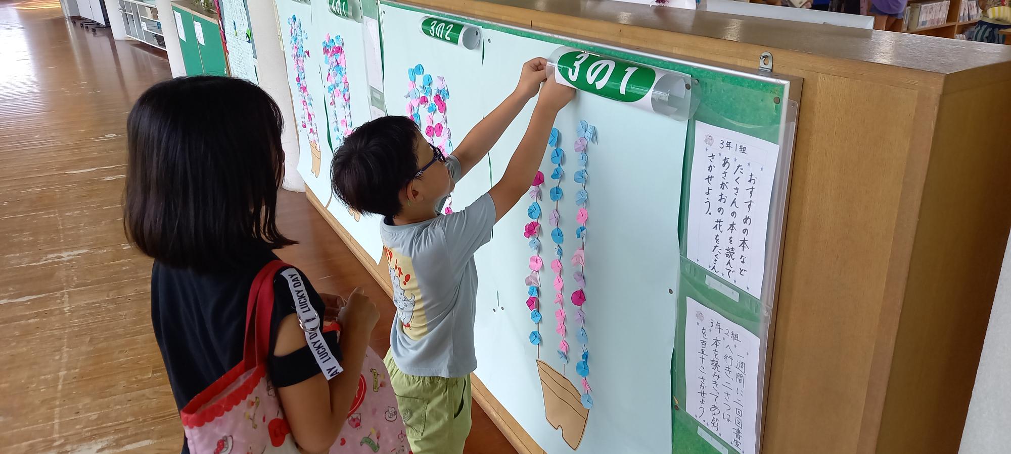 読書をして朝顔を貼る子