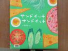 チーズ、卵、トマト、キュウリ、ハムの絵が描かれている「サンドイッチサンドイッチ」という本の表紙の写真