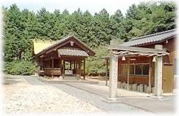 石で造られた鳥居の奥に、林に囲まれた拝殿がある白山神社の写真