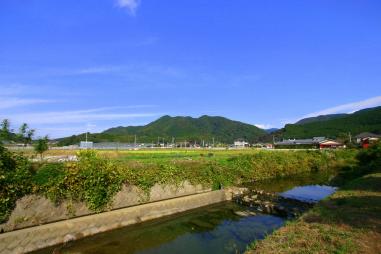 手前の川の奥に見える、遠見岳の山並みの写真