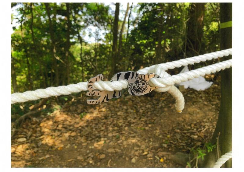 登山道に設置された白いロープの繋ぎ目に虎を描いた金具の写真